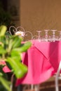 Clean upturned wine glasses on a pink tablecloth. Table setting. Empty restaurant terrace, siesta