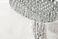 Clean water drops pours from the shower head in the light bathroom Royalty Free Stock Photo