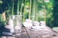 Clean water pouring into the glass next to the stones on the old wooden table. Japanese style. Royalty Free Stock Photo