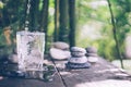 Clean water pouring into the glass next to the stones on the old table. Japanese style Royalty Free Stock Photo