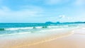 Clean white beach golden brown sand and blue sea under clear blue sky in a sunny day, mountain on background Royalty Free Stock Photo