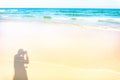 Clean white beach golden brown sand and small wave from blue sea under clear blue sky in a sunny day, a person shadow on the left Royalty Free Stock Photo