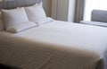 Clean white bed in hotel. White comfortable pillow on bed in bedroom. Bed sheets and pillows. Royalty Free Stock Photo