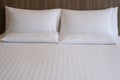 Clean white bed in hotel. White comfortable pillow on bed in bedroom. Bed sheets and pillows. Royalty Free Stock Photo