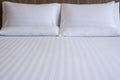 Clean white bed in hotel. White comfortable pillow on bed in bedroom. Bed sheets and pillows. Royalty Free Stock Photo