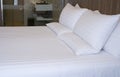 Clean white bed in hotel. White comfortable pillow on bed in bedroom. Bed sheets and pillows. Royalty Free Stock Photo