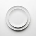 Clean white ceramic plates stacked top view minimalist tableware kitchen essentials white background Royalty Free Stock Photo