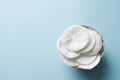 Clean white cotton stack of disk for beauty face hygiene with selective focus on blue neutral background. Cosmetic softness pure