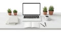 A clean white desk setup with a laptop, notebooks, plants, and coffee workspace office Royalty Free Stock Photo