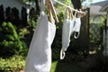 Clean white face masks with ear loops hanging on clothes line