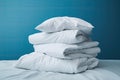 Clean white linens on the bed against a blue wall Royalty Free Stock Photo