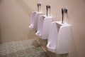 Clean white male lavatory urinal sanitary ware vessel fixture or fitting attached upright to a wall used by men for urinating or e Royalty Free Stock Photo