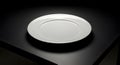 A Clean White Plate on a Dark Surface Royalty Free Stock Photo