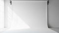 Seamless white studio backdrop with soft natural light casting gentle shadows from a nearby window Royalty Free Stock Photo