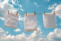 Clean white tissues drying on a clothesline under a bright blue sky with fluffy white clouds Royalty Free Stock Photo