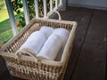 Clean white towels in a basket on a wooden and balcony