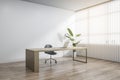 Clean wooden and concrete office interior with mock up place, workplace desk, laptop, chair, decorative plant, blinds and daylight Royalty Free Stock Photo