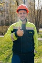 A clean young builder shows sincere emotions of joy. man in special clothes and a hard hat Royalty Free Stock Photo