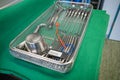 Cleaned and disinfected instrument tray for performing a uterus scraping lies on a green cloth