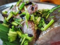 A cleaned grouper fish is prepared with black beans and some home ingredients is ready to steam.