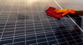 Cleaner cleaning solar panel on roof. Solar panel or photovoltaic module maintenance. Sustainable resource and renewable energy Royalty Free Stock Photo