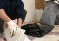 Repair worker collects light trash in black bags