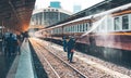 Cleaner Helping to clean the locomotives Which is parked on the platfrom With high-pressure water injection Royalty Free Stock Photo