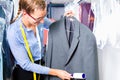 Cleaner in laundry shop checking clean clothes Royalty Free Stock Photo