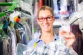 Cleaner in laundry shop checking clean clothes Royalty Free Stock Photo