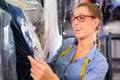 Cleaner in laundry shop checking clean clothes Royalty Free Stock Photo