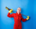 A cleaner in a red uniform holding a mop behind her back is happy and smiling. Royalty Free Stock Photo