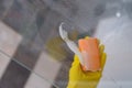 Cleaner in rubber gloves washing glass in bathroom with detergent and sponge closeup Royalty Free Stock Photo