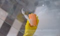 Cleaner in rubber gloves washing glass in bathroom with detergent and sponge closeup Royalty Free Stock Photo