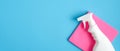 Cleaner spray bottle and pink rag on blue background. Cleaning service banner mockup. Housecleaning and housekeeping concept. Flat