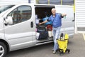 Cleaner standing next to van