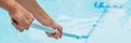 Cleaner of the swimming pool . Man in a blue shirt with cleaning equipment for swimming pools, sunny BANNER, long format