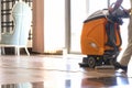 Cleaner washing floor in hotel using special machine closeup