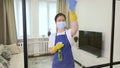 cleaner woman in yellow gloves wipes a glass wall in a stylish apartment