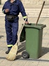 Cleaner worker stands next to a garbage can on the street Royalty Free Stock Photo
