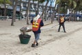 Cleaners clearing the beach of Si Racha from garbage and waste