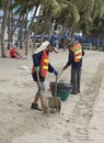 Cleaners clearing the beach of Si Racha from garbage and waste