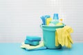 Cleaners and detergents in bucket, accessories for cleaning various surfaces and rooms blue background Royalty Free Stock Photo