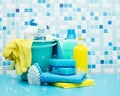 Cleaners and detergents in a bucket, cleaning accessories, blue background with soap bubbles Royalty Free Stock Photo