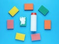 Cleaning agent in a white jar and colorful sponges on a blue background. Minimal concept of washing and cleaning Royalty Free Stock Photo