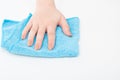 Cleaning of apartments, offices, cottages, warehouses, garages. Female hand wipes a white surface with a blue microfiber cloth