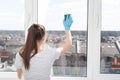 Cleaning of apartments, offices, cottages, warehouses, garages. Young girl with cleaning products sponges a window