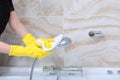 Cleaning in the bathroom of an expensive hotel. Hands in rubber gloves wipe chrome surfaces. Unrecognizable photo Royalty Free Stock Photo