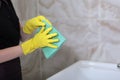 Cleaning in the bathroom. Marble tiles on the walls. Unrecognizable photo. Only hand. Copy of the space.