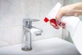 Cleaning in the bathroom. Woman disinfects the sink.