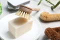 Cleaning brushes, soap bar and plates on table, closeup. Dish washing supplies